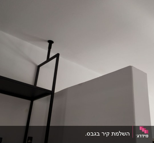 קיר גבס לבן עם מדף מתכת שחור